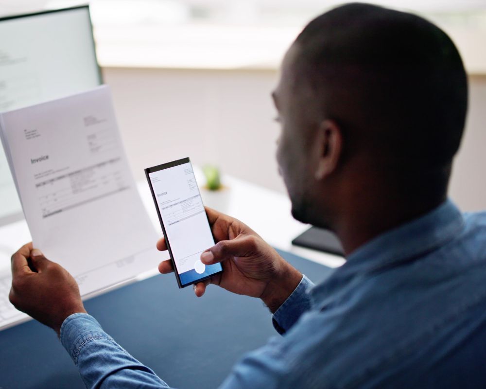 Person capturing a paper supplier invoice using a smartphone